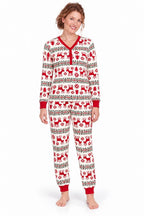 Woman wearing white Christmas pajamas with red reindeer, snowflakes, red cuffs and a buttoned V-neck.