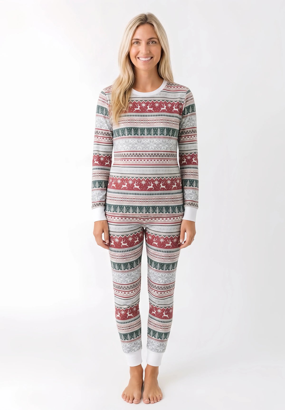 Woman modeling light grey Christmas pajamas with red reindeer bands, green tree rows and white cuffs.