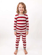Girl wearing a red and white striped long-sleeve Christmas pajama set with grey cuffs.